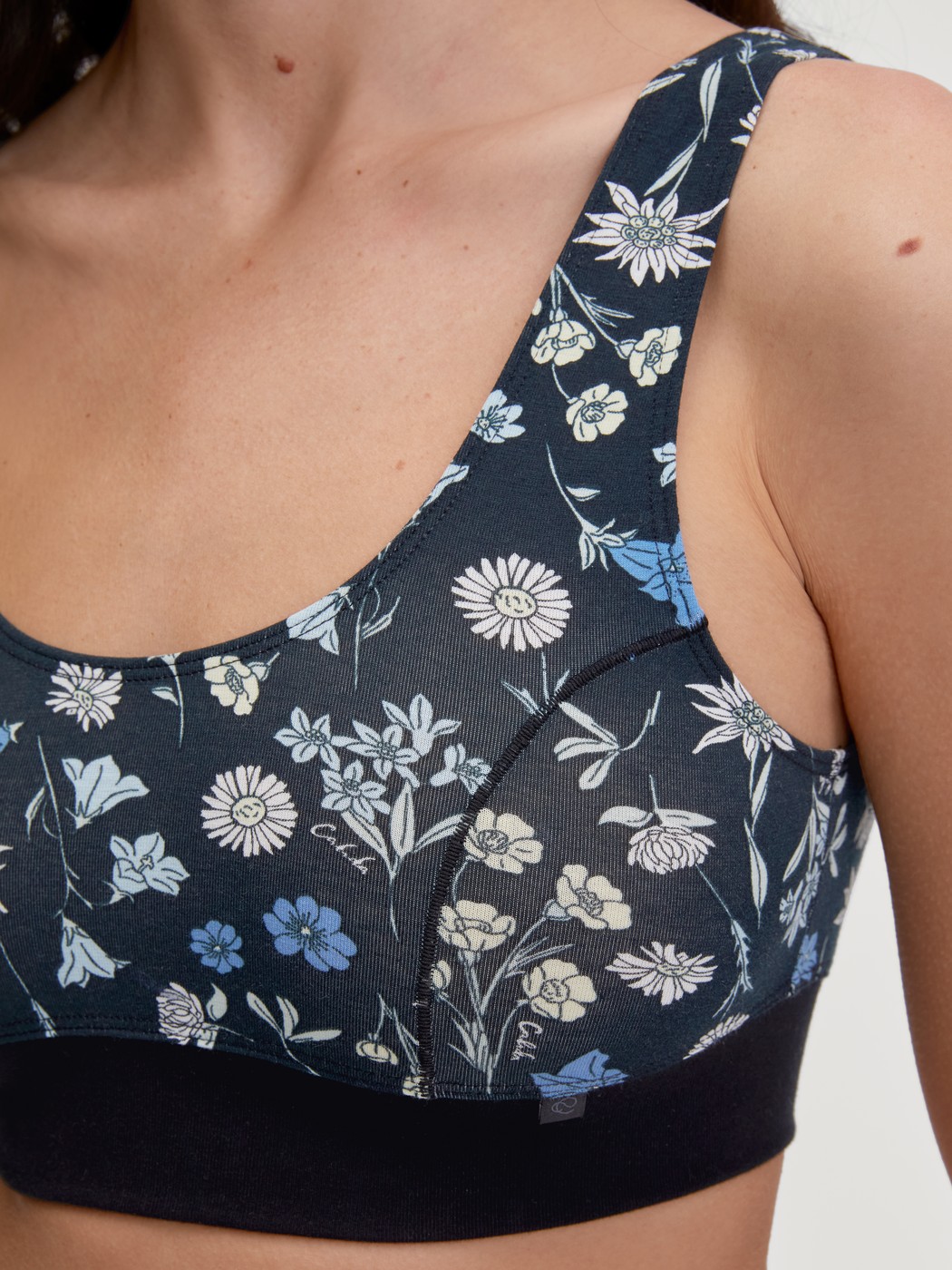 Damen-Model trägt Bustier mit Softbund aus Baumwolle in Schwarz, Floral aus Serie Elastic Trend von CALIDA, Detail