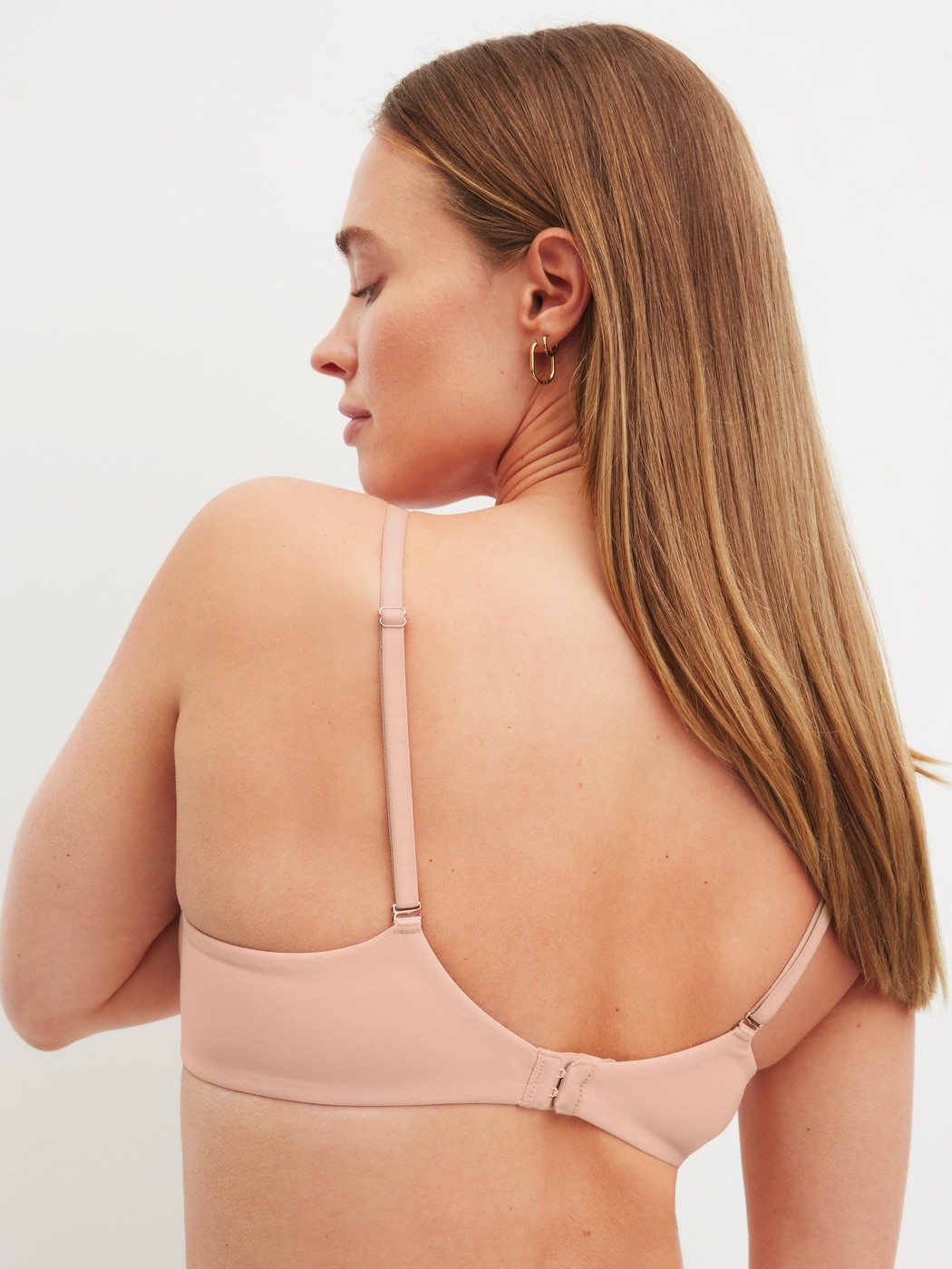 Women model is wearing Moulded Bra with Multiway Straps made of Polyamide in Beige, Unicoloured from the Sleek Skin series by CALIDA, Back view