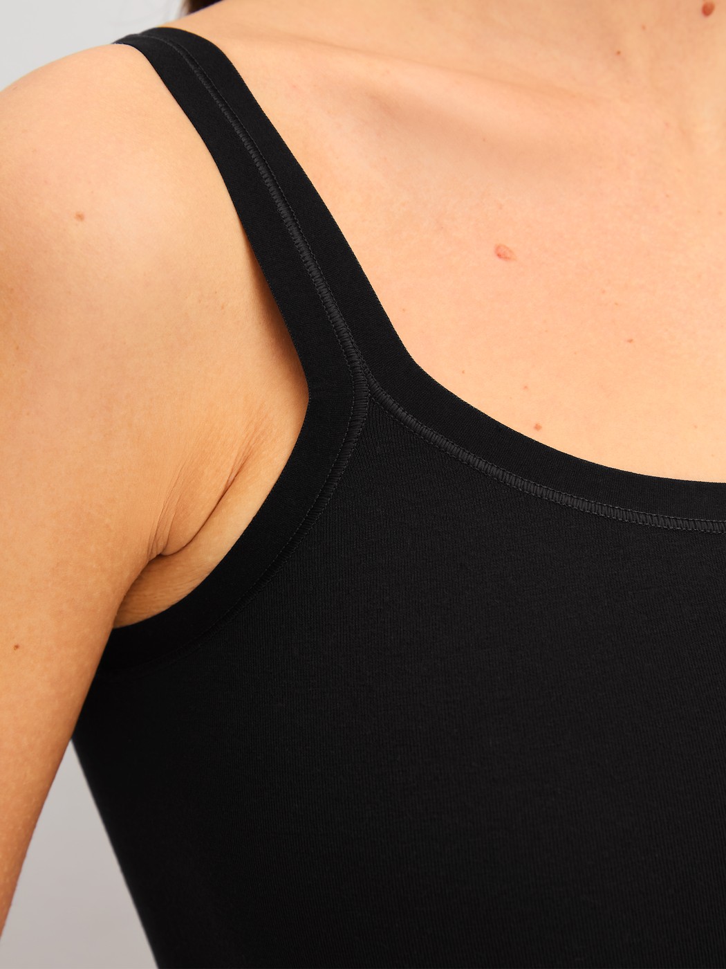 La modella / Il modello Donna indossa Top con spalline in Modal di colore Nero, Tinta unita, della serie Seamless Natural di CALIDA, Dettaglio