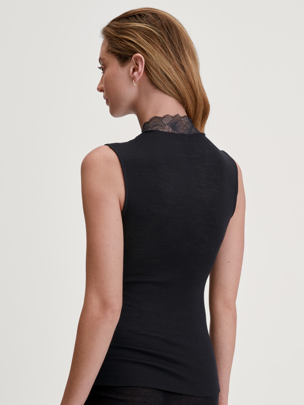 Women model is wearing Tank top made from wool and silk made of Lace in Black, Lace from the Silky Wool Glam series by CALIDA, Back view