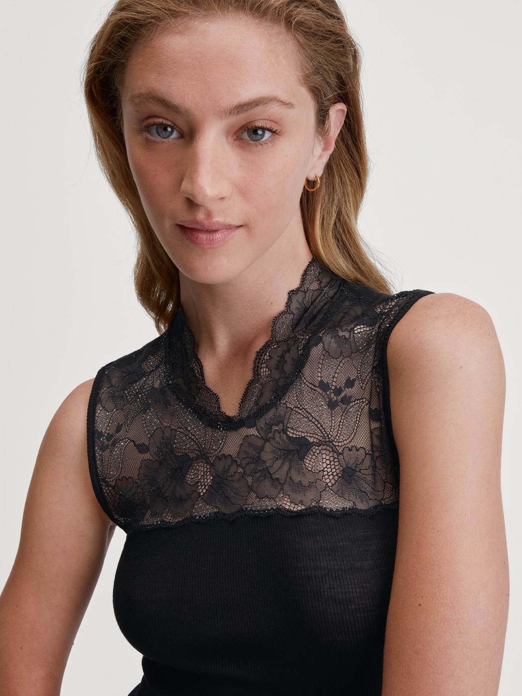 Women model is wearing Tank top made from wool and silk made of Lace in Black, Lace from the Silky Wool Glam series by CALIDA, Detail