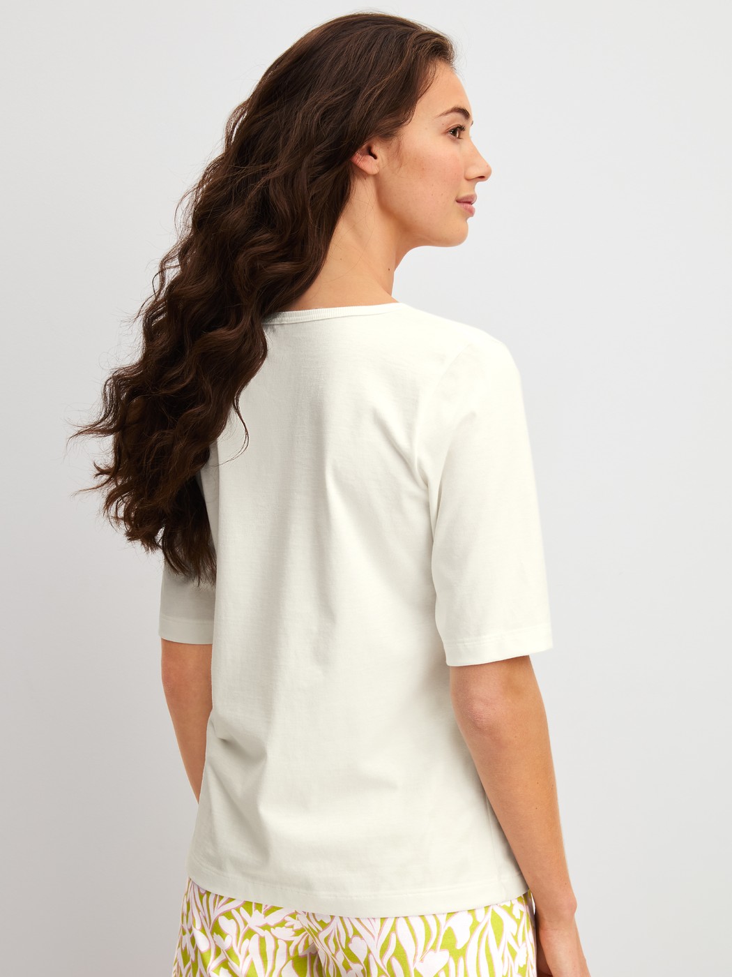 Women model is wearing Short-sleeved shirt with V-neck made of 100% Cotton in White, Unicoloured from the Late Bloom M&M series by CALIDA, Back view