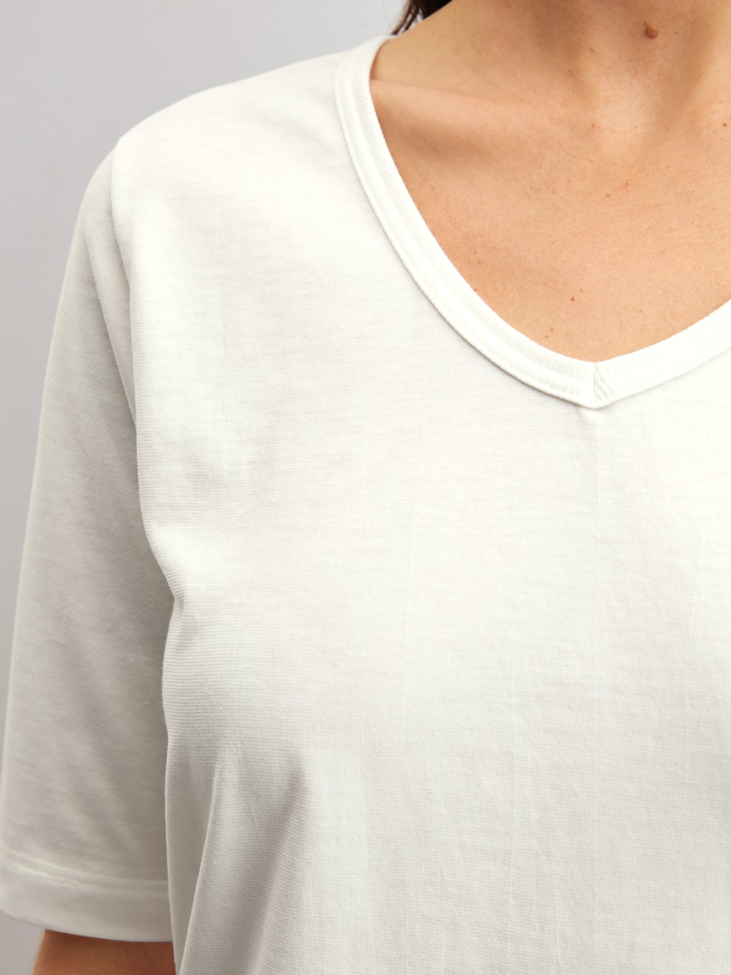 Women model is wearing Short-sleeved shirt with V-neck made of 100% Cotton in White, Unicoloured from the Late Bloom M&M series by CALIDA, Detail