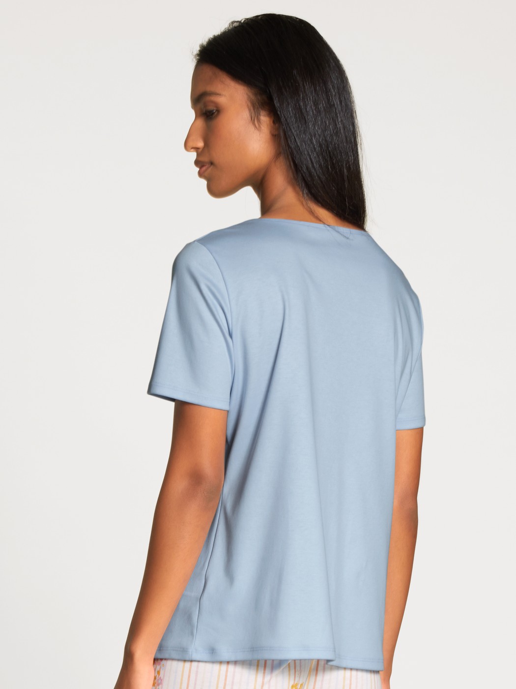 Damen-Model trägt Kurzarm-Shirt aus 100% Baumwolle in Blau, Einfarbig aus Serie Favourites Sunflower von CALIDA, Rückansicht