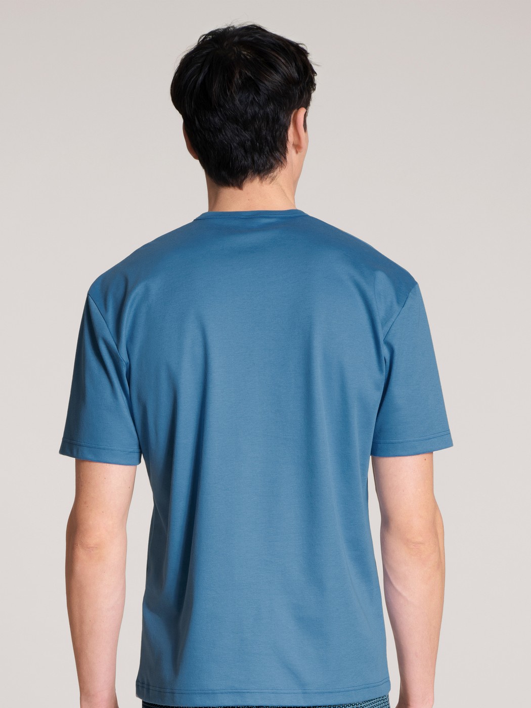 Herren-Model trägt Kurzarm-Shirt aus 100% Baumwolle in Blau, Einfarbig aus Serie Remix Xtra von CALIDA, Rückansicht