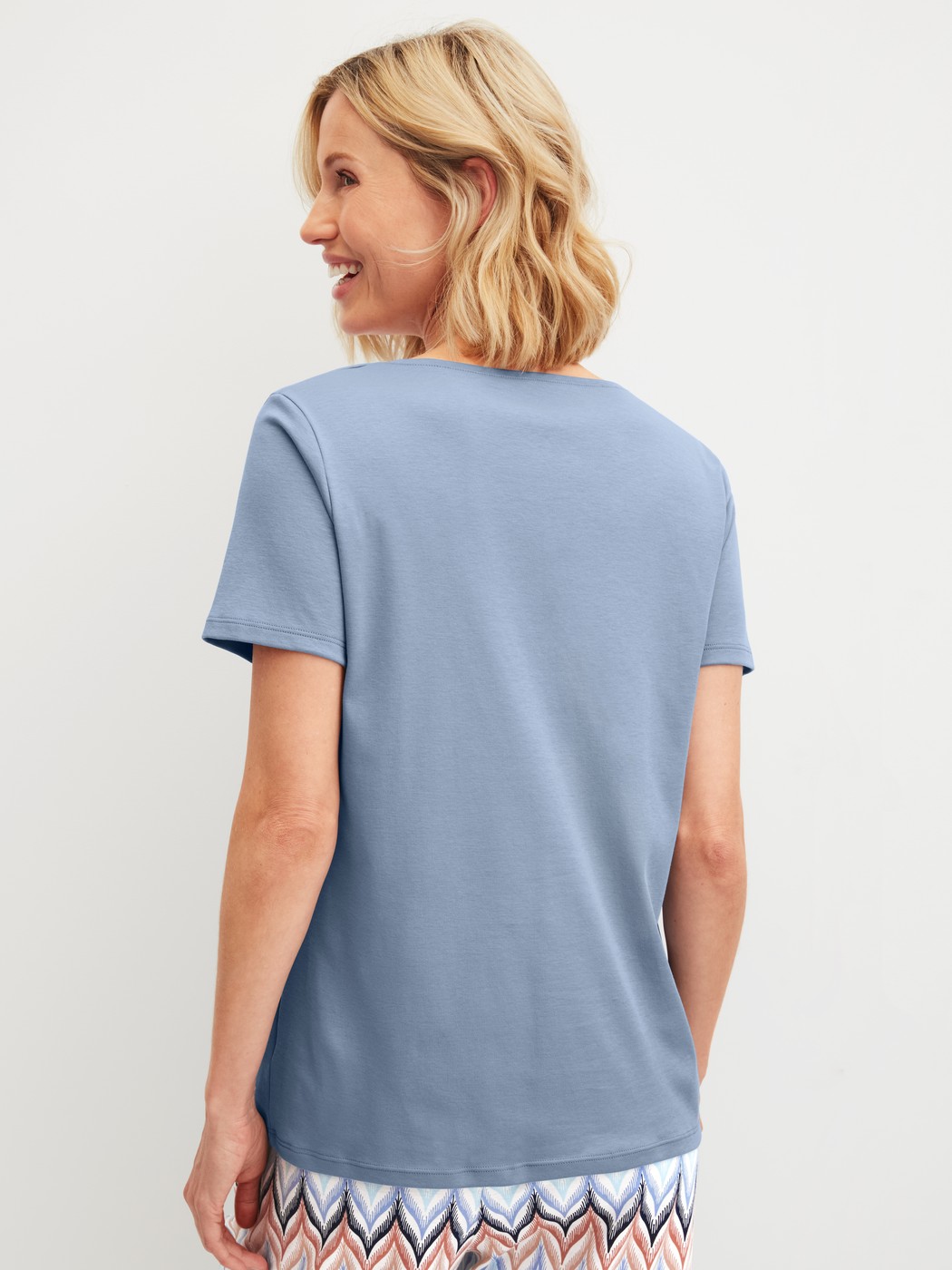 Damen-Model trägt Kurzarm-Shirt aus 100% Baumwolle in Blau, Einfarbig aus Serie Favourites Tiles von CALIDA, Rückansicht