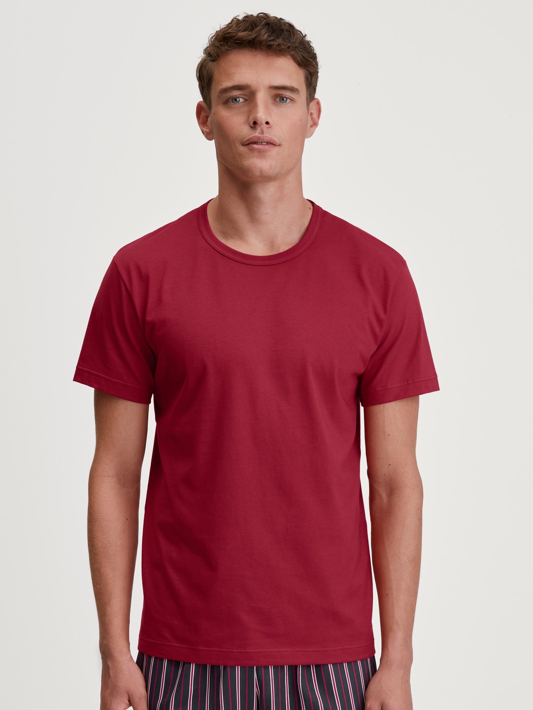 Men model is wearing Short-sleeved shirt made of 100% Cotton in Red, Unicoloured from the Remix Basic Sleep series by CALIDA, Front view