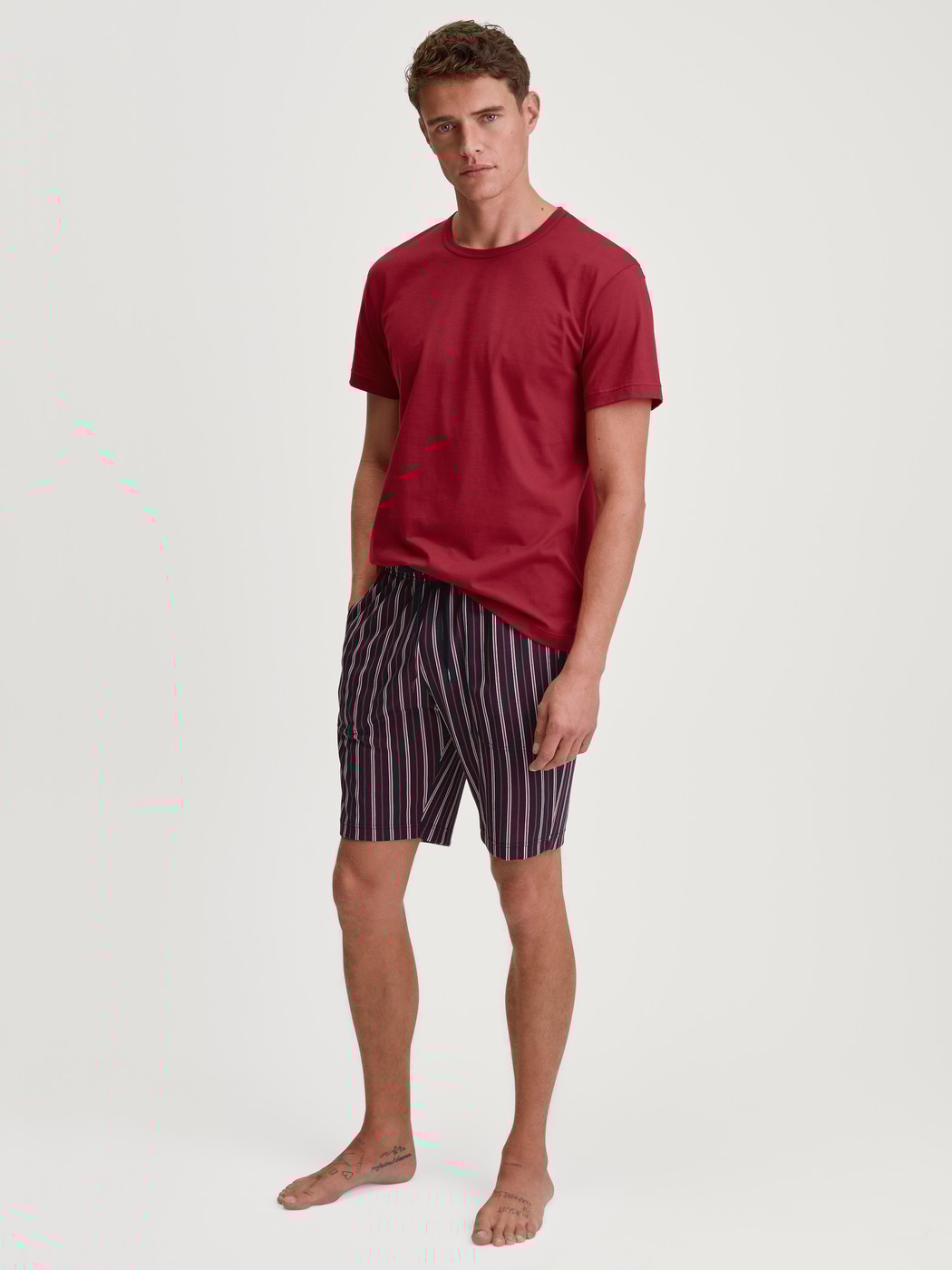 Men model is wearing Short-sleeved shirt made of 100% Cotton in Red, Unicoloured from the Remix Basic Sleep series by CALIDA, Outfit