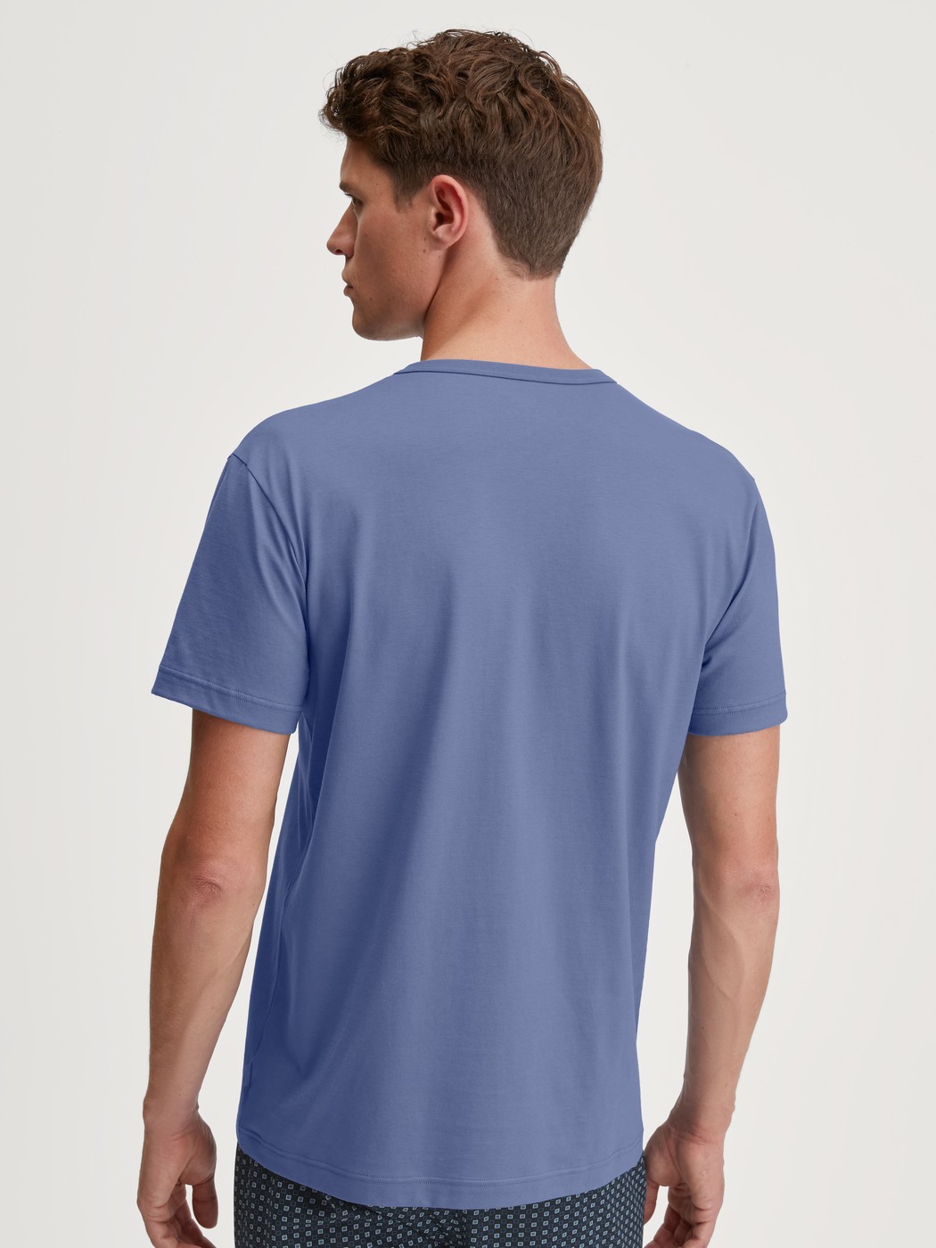 Men model is wearing Short-sleeved shirt made of 100% Cotton in Blue, Unicoloured from the Remix Basic Sleep series by CALIDA, Back view