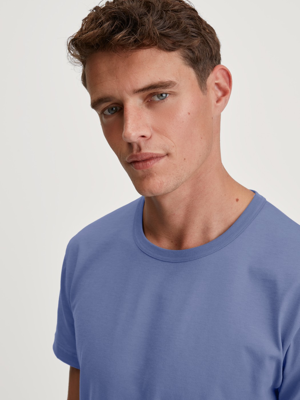 Men model is wearing Short-sleeved shirt made of 100% Cotton in Blue, Unicoloured from the Remix Basic Sleep series by CALIDA, Detail