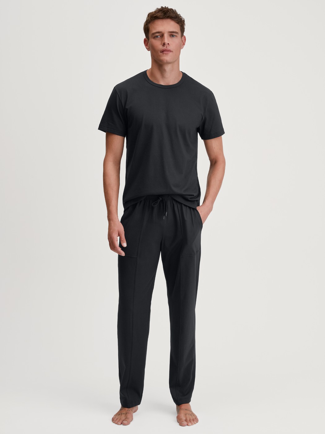 Herren-Model trägt Kurzarm-Shirt aus 100% Baumwolle in Schwarz, Einfarbig aus Serie RMX Sleep Leisure von CALIDA, Outfit