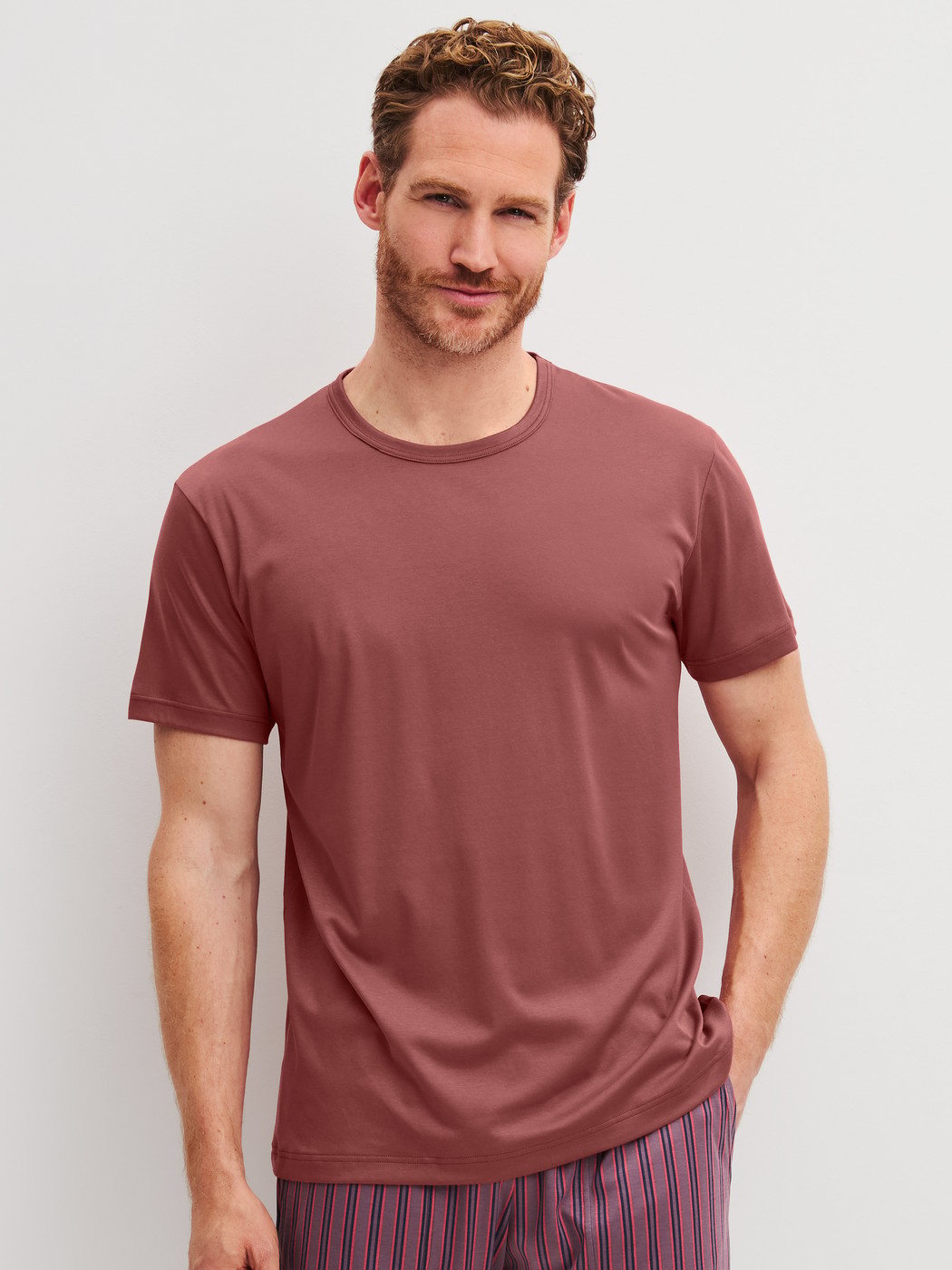 Herren-Model trägt Kurzarm-Shirt aus Baumwolle in Orange, Einfarbig aus Serie RMX Sleep Superlight von CALIDA, Vorderansicht