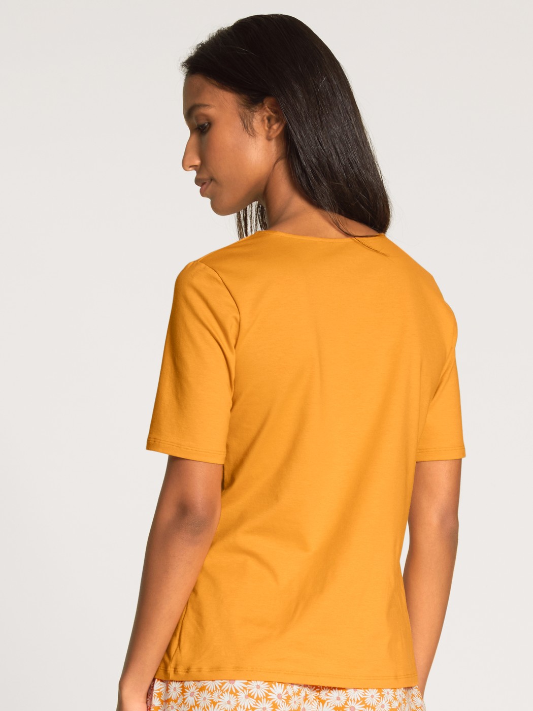 Damen-Model trägt Kurzarm-Shirt aus Baumwolle in Gelb, Einfarbig aus Serie Favourites Sunflower von CALIDA, Rückansicht