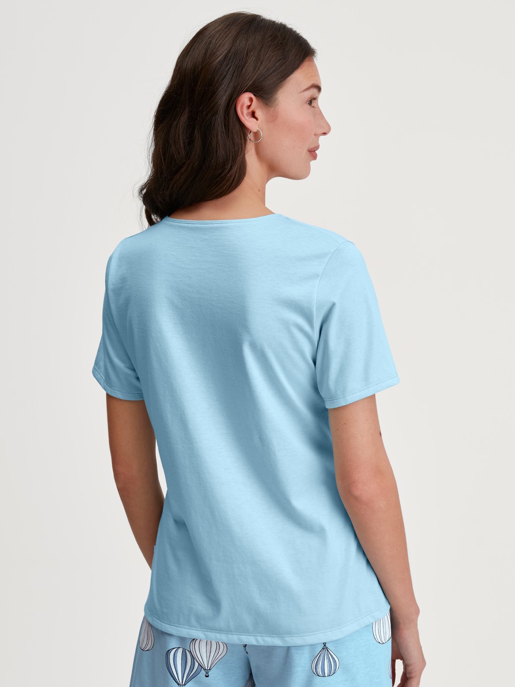 Damen-Model trägt T-shirt mit V-Neck aus 100% Baumwolle in Blau, Einfarbig aus Serie Favourites Journey von CALIDA, Rückansicht