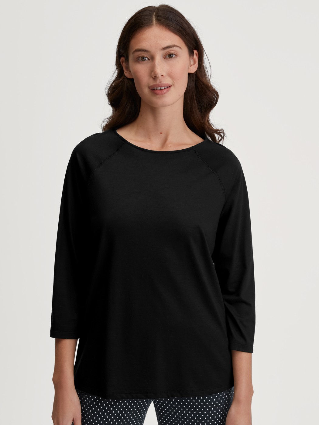 Damen-Model trägt Shirt mit 3/4-Arm aus Baumwolle in Schwarz, Einfarbig aus Serie Favourites Journey von CALIDA, Vorderansicht