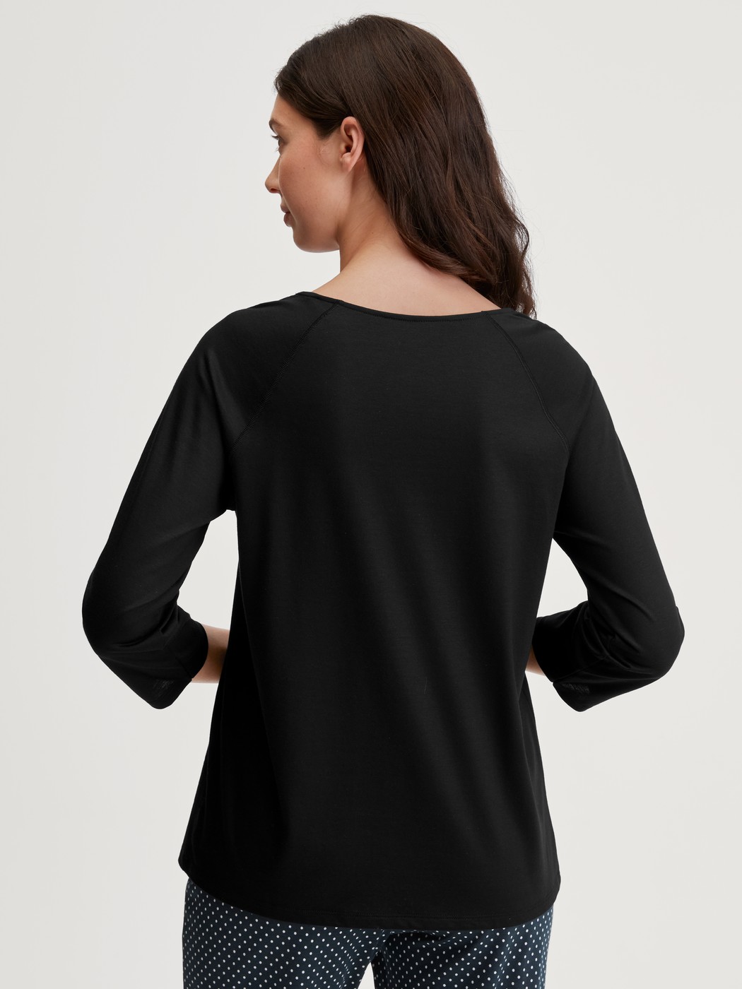 Damen-Model trägt Shirt mit 3/4-Arm aus Baumwolle in Schwarz, Einfarbig aus Serie Favourites Journey von CALIDA, Rückansicht