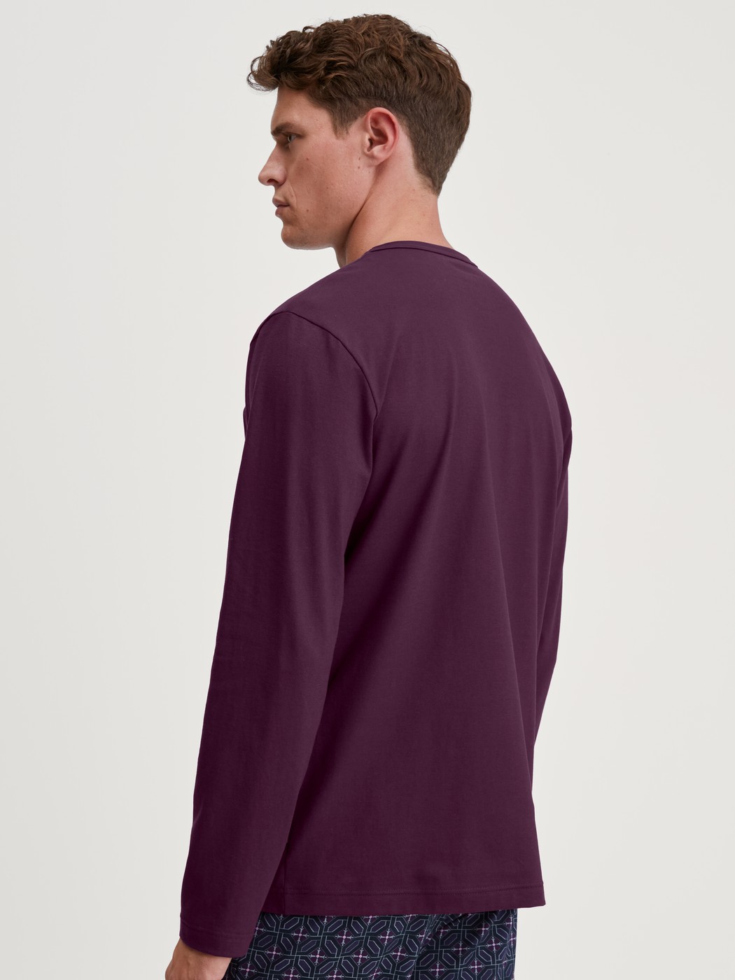 Herren-Model trägt Langarm-Shirt aus 100% Baumwolle in Rot, Einfarbig aus Serie RMX Sleep Holiday von CALIDA, Rückansicht