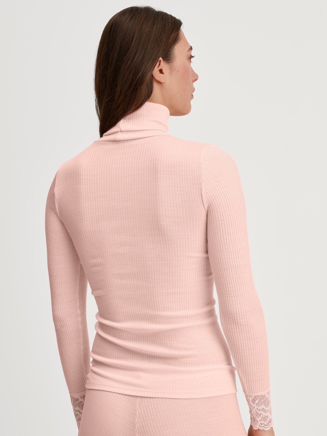 Damen-Model trägt Langarm-Shirt mit Rollkragen aus Wolle-Seide aus Wolle in Rosa, Spitze aus Serie Silky Wool Joy von CALIDA, Rückansicht
