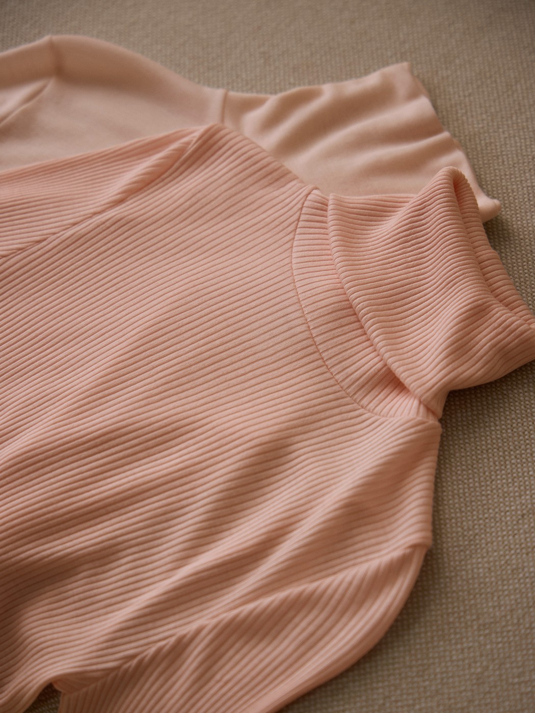 Damen-Model trägt Langarm-Shirt mit Rollkragen aus Wolle-Seide aus Wolle in Rosa, Spitze aus Serie Silky Wool Joy von CALIDA