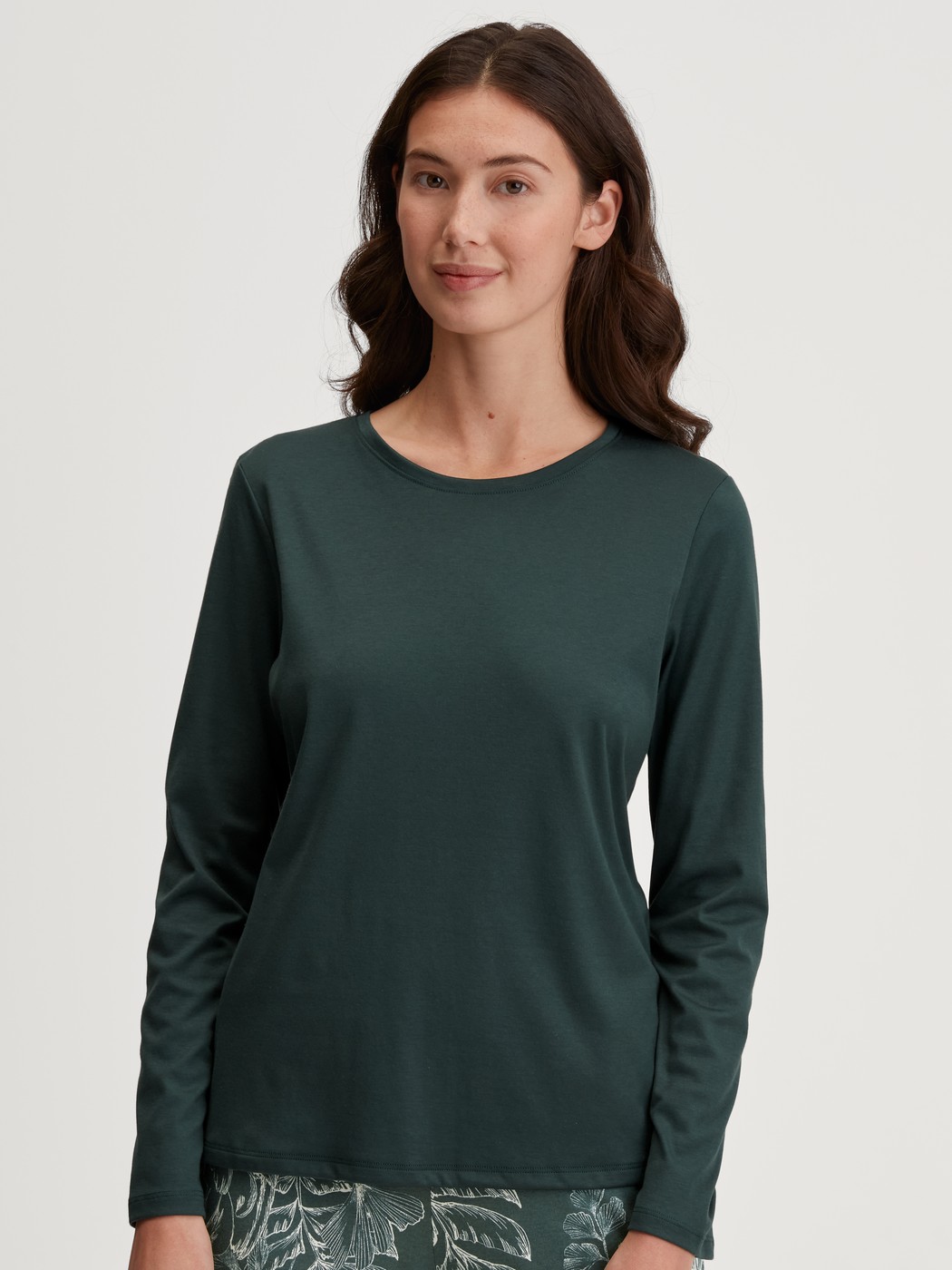 Damen-Model trägt Langarm-Shirt aus 100% Baumwolle in Grün, Einfarbig aus Serie Favourites Botanic von CALIDA, Vorderansicht