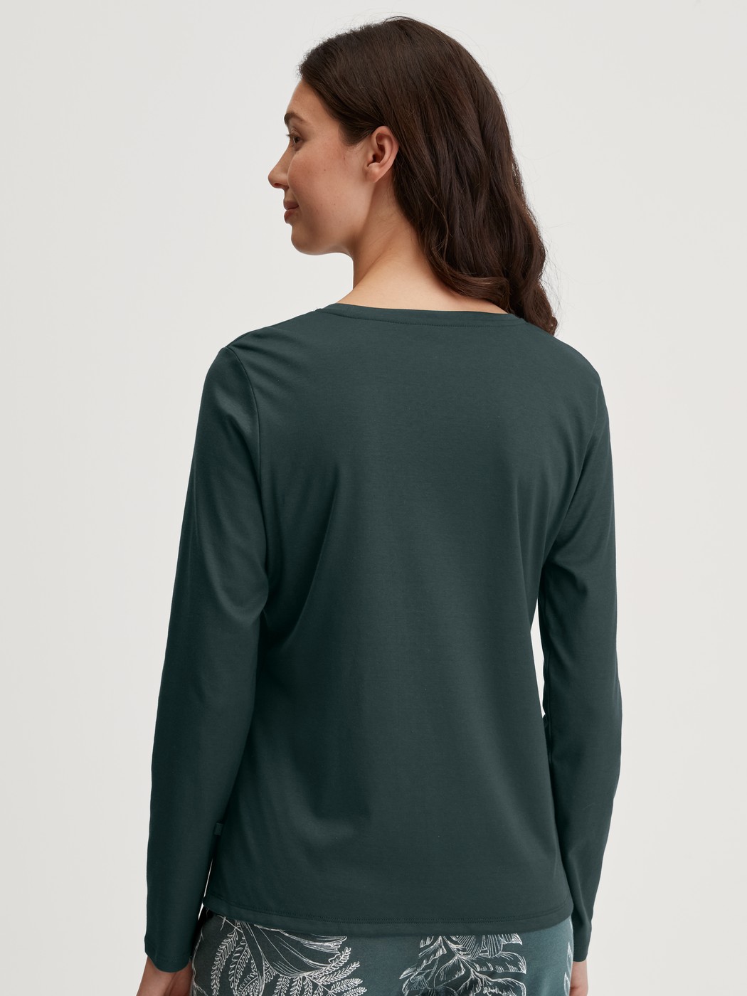 Damen-Model trägt Langarm-Shirt aus 100% Baumwolle in Grün, Einfarbig aus Serie Favourites Botanic von CALIDA, Rückansicht