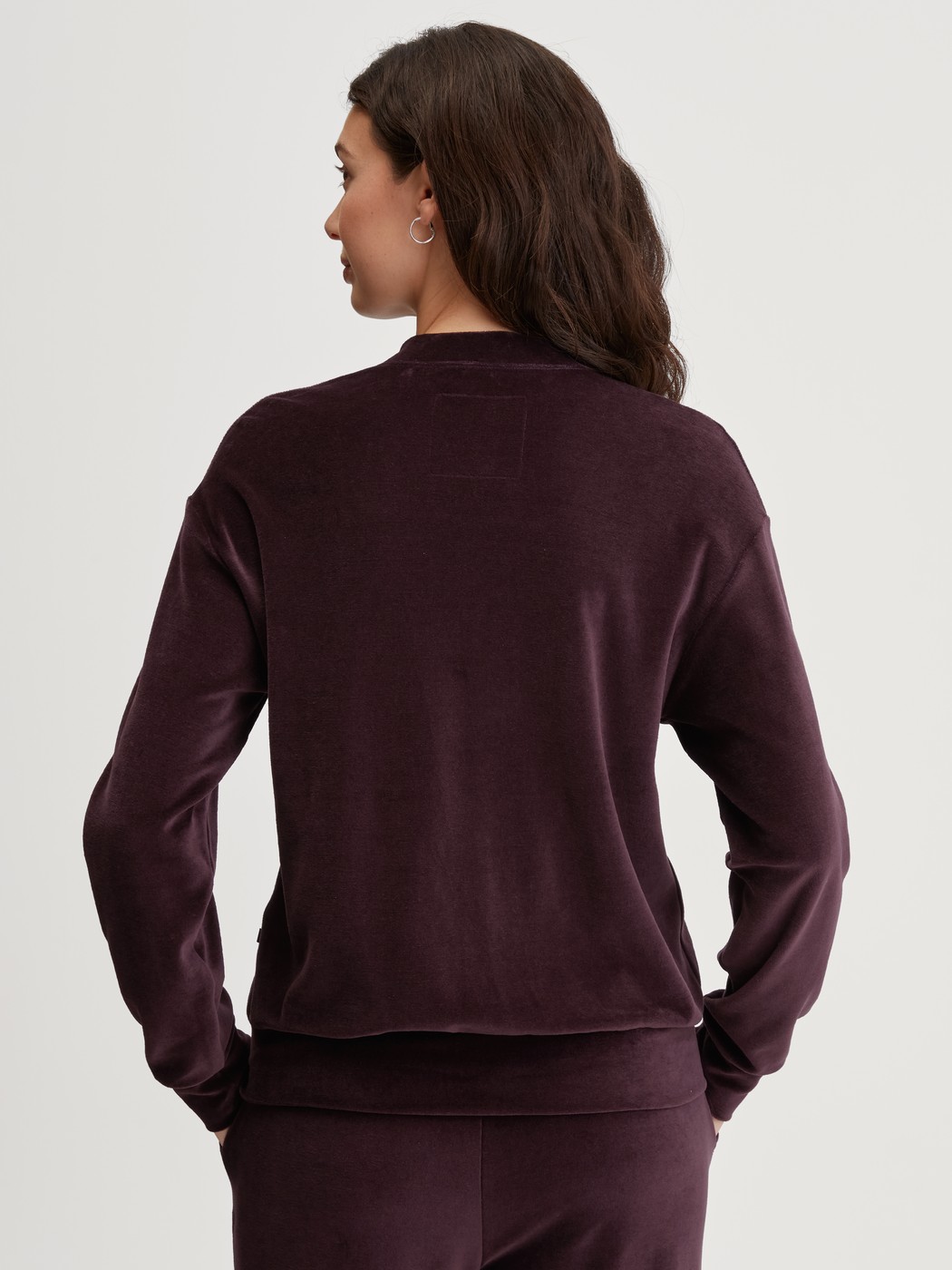 Damen-Model trägt Lounge-Jacke aus Velours aus Baumwolle in Rot, Einfarbig aus Serie Lounge Velours von CALIDA, Rückansicht