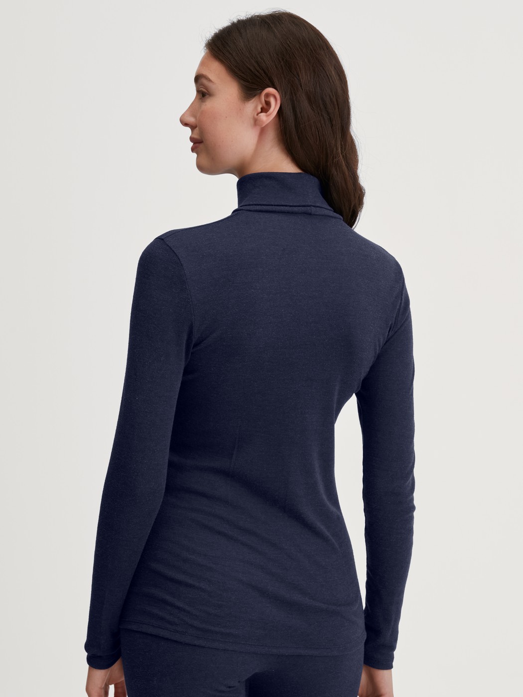Women model is wearing Long-sleeve turtleneck shirt in wool-silk made of Wool in Blue, Unicoloured from the True Confidence series by CALIDA, Back view