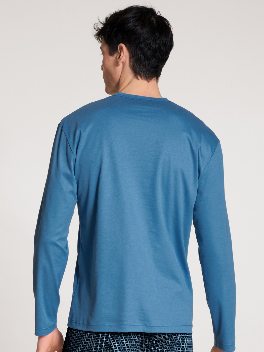 Herren-Model trägt Langarm-Shirt aus 100% Baumwolle in Blau, Einfarbig aus Serie Remix Xtra von CALIDA, Rückansicht