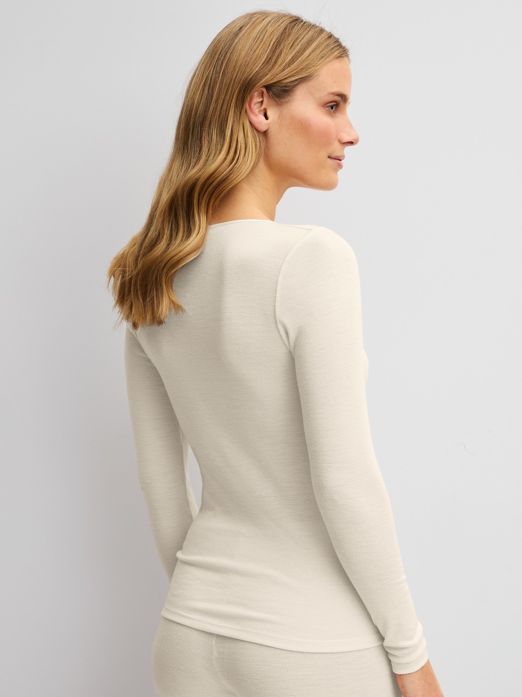 La modella / Il modello Donna indossa Maglia a maniche lunghe in lana e seta in Lana di colore Beige, Tinta unita, della serie True Confidence di CALIDA, Vista posteriore