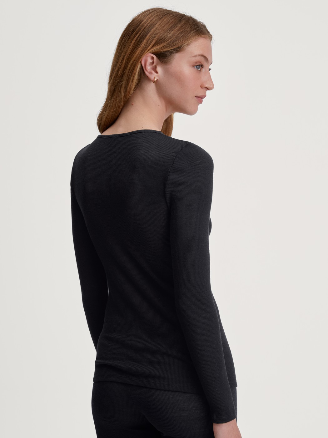Damen-Model trägt Langarm-Shirt aus Wolle-Seide aus Spitze in Schwarz, Spitze aus Serie Silky Wool Glam von CALIDA, Rückansicht