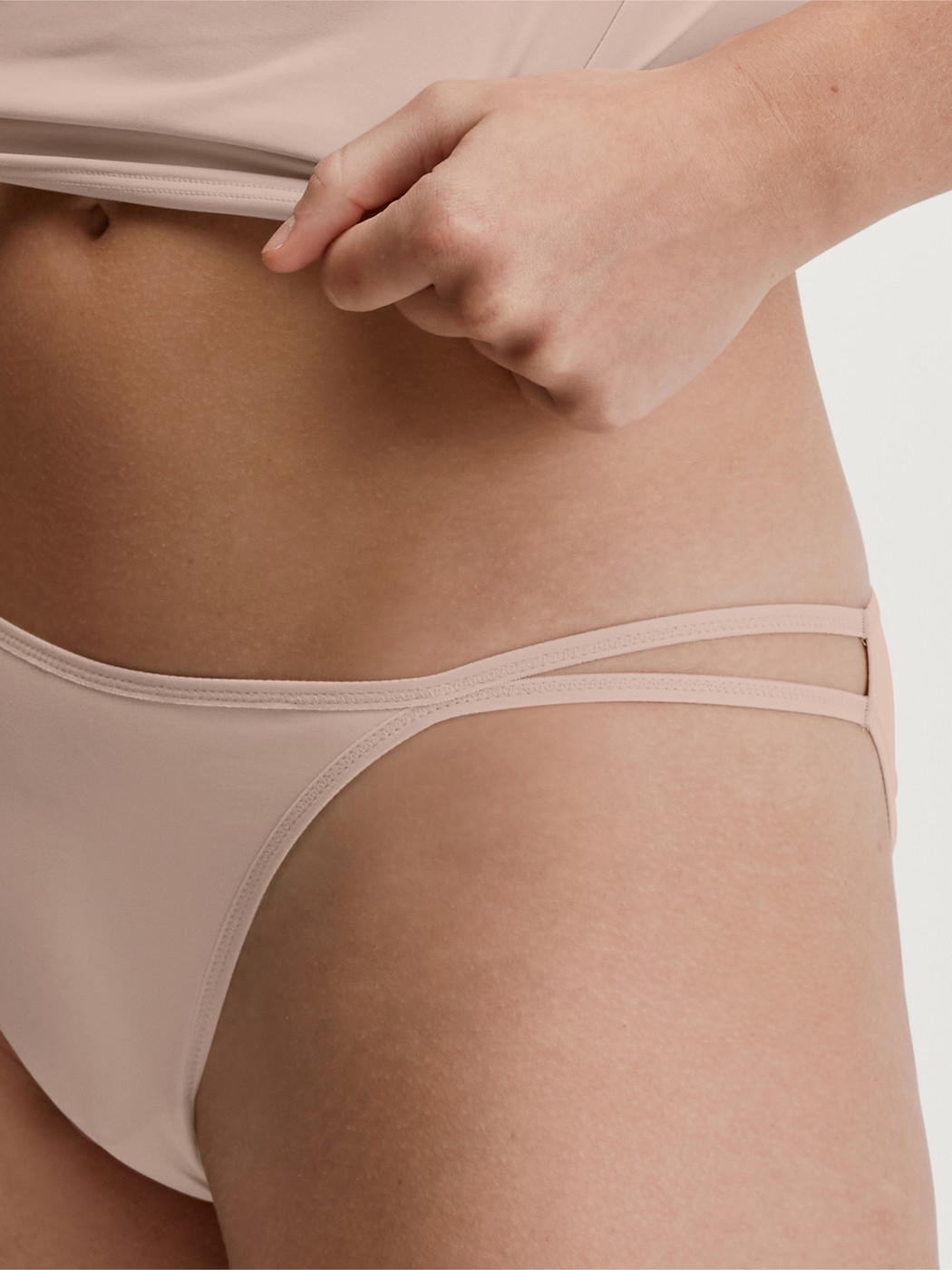 Le mannequin Femme porte le/la Tanga taille basse en Polyamide de couleur Beige, Unicolore, de la série Sleek Skin de CALIDA, Vue de face