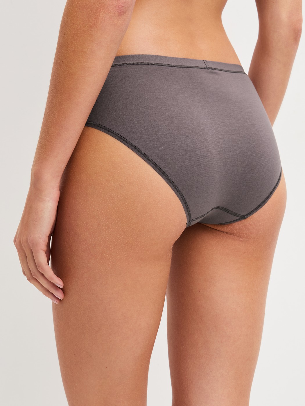 Damen-Model trägt Slip, regular cut aus Baumwolle in Braun, Einfarbig aus Serie Natural Comfort von CALIDA, Rückansicht