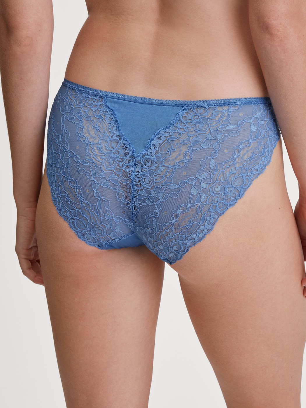 Damen-Model trägt Slip, regular cut aus Spitze in Blau, Spitze aus Serie Sensual Secrets von CALIDA, Rückansicht