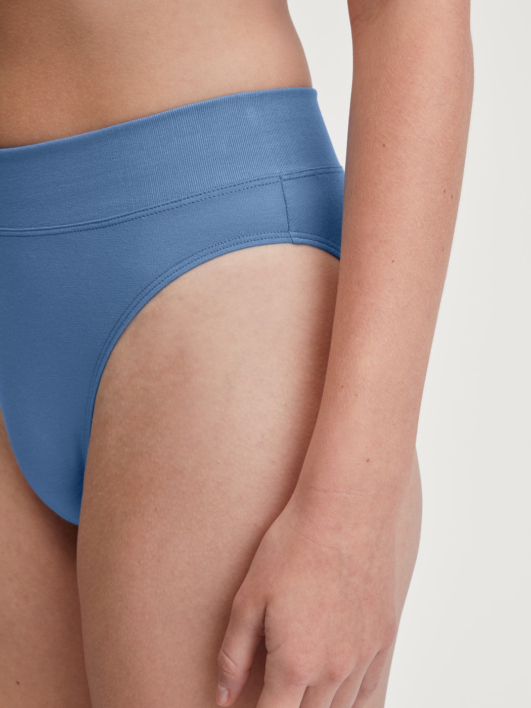 Damen-Model trägt Slip mit Softbund, high waist aus Baumwolle in Blau, Einfarbig aus Serie Elastic von CALIDA, Detail