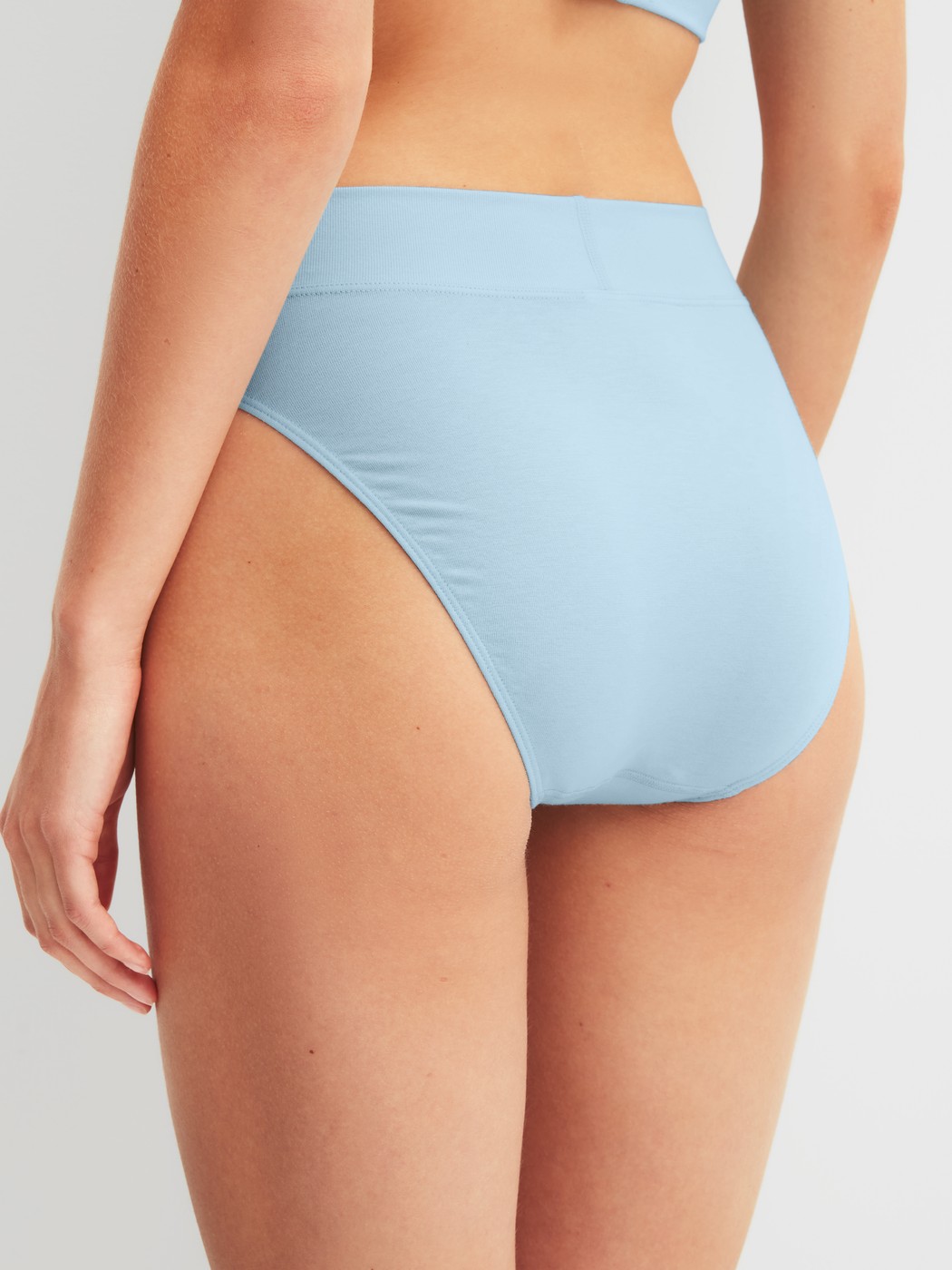 Damen-Model trägt Slip mit Softbund, high waist aus Baumwolle in Blau, Einfarbig aus Serie Elastic von CALIDA, Rückansicht