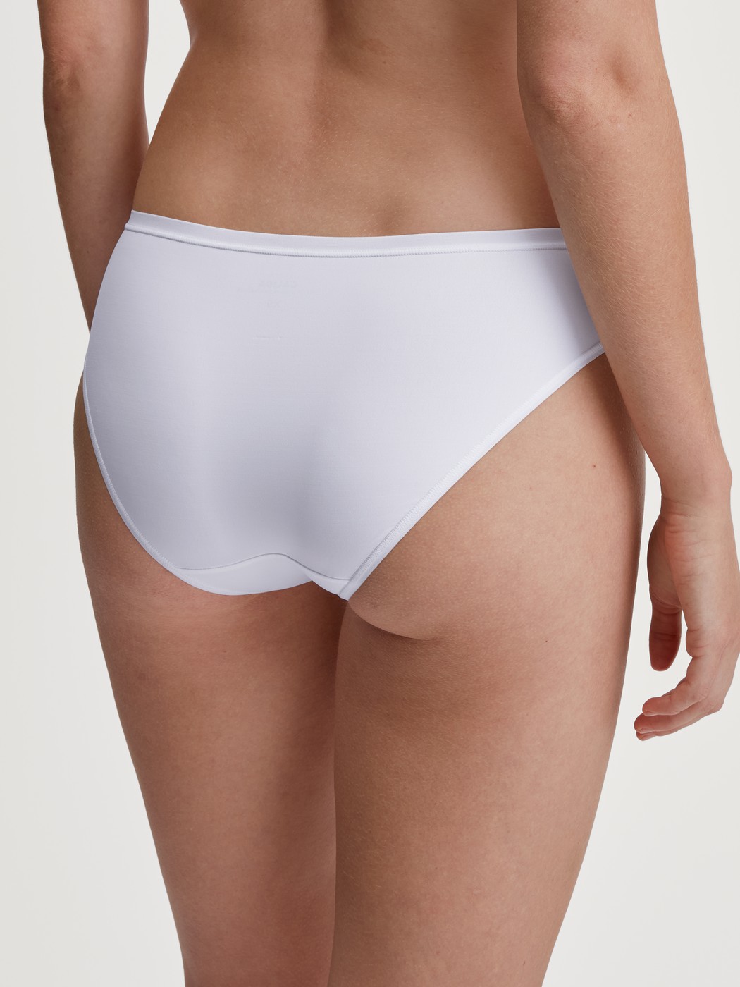 Damen-Model trägt Slip, regular cut aus Polyamid in Weiß, Einfarbig aus Serie Sleek Skin von CALIDA, Rückansicht