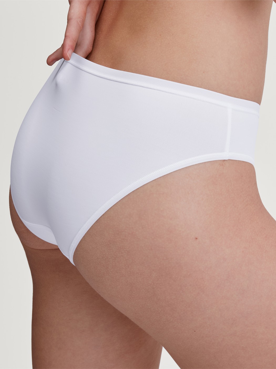 Damen-Model trägt Slip, regular cut aus Polyamid in Weiß, Einfarbig aus Serie Sleek Skin von CALIDA, Vorderansicht