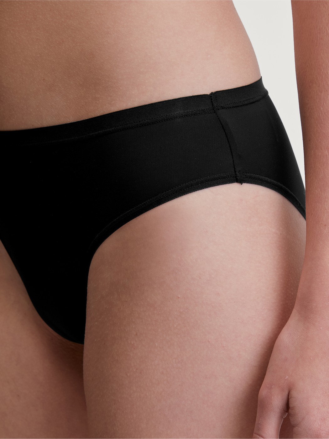 La modella / Il modello Donna indossa Slip in Poliammide di colore Nero, Tinta unita, della serie Sleek Skin di CALIDA, Vista frontale