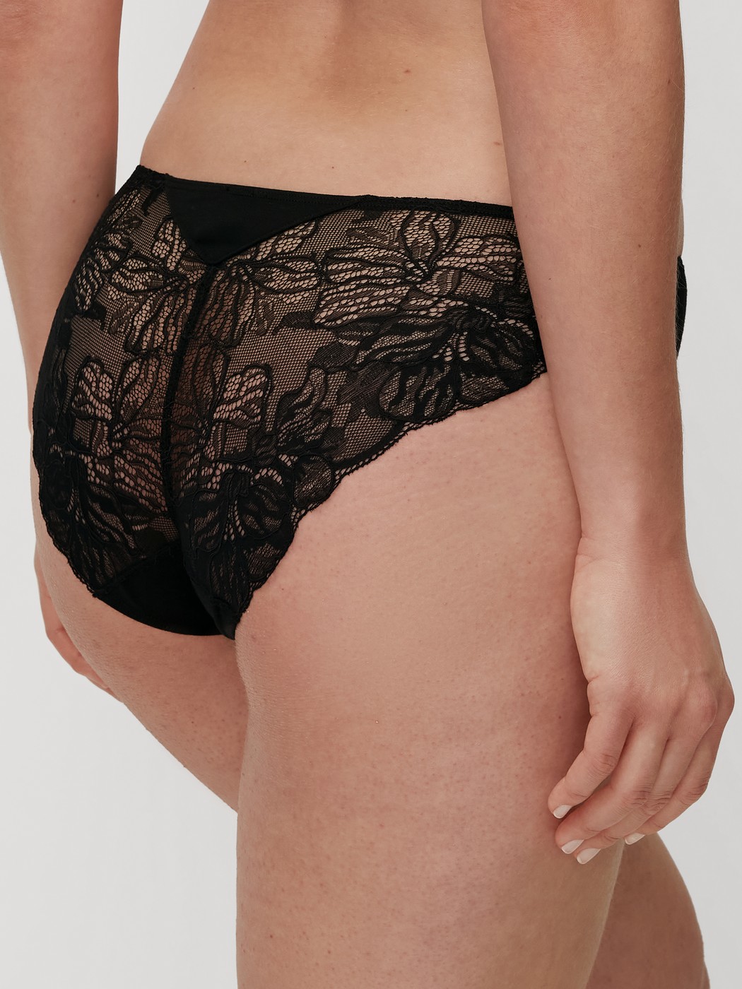 Damen-Model trägt Slip, regular cut aus Modal in Schwarz, Spitze aus Serie Seduction Lace von CALIDA, Rückansicht