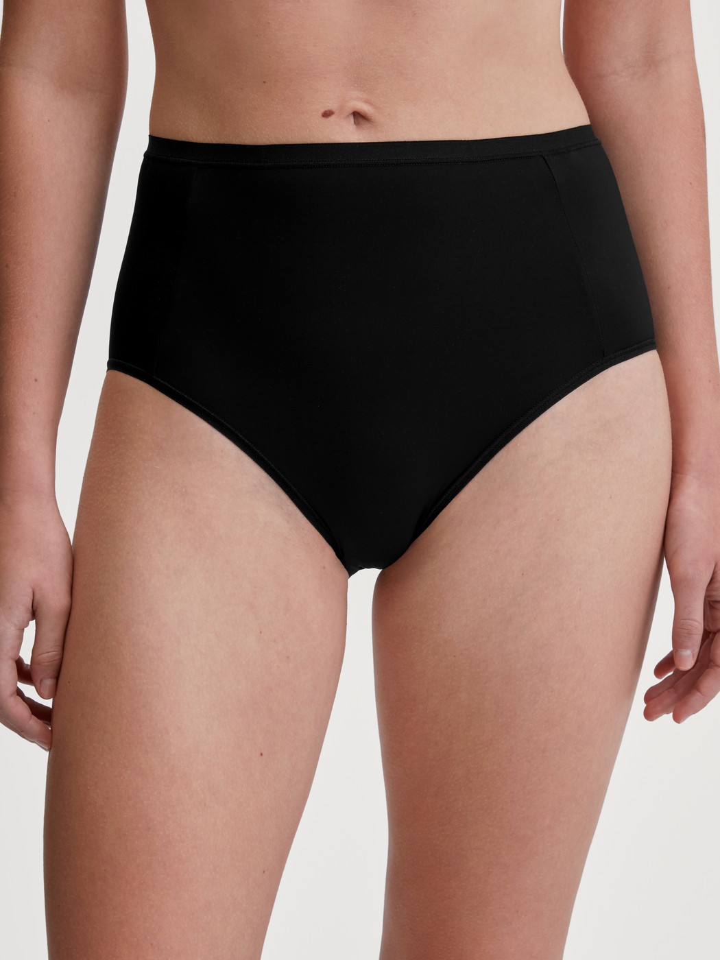 Damen-Model trägt Slip, high waist aus Polyamid in Schwarz, Einfarbig aus Serie Sleek Skin von CALIDA, Vorderansicht