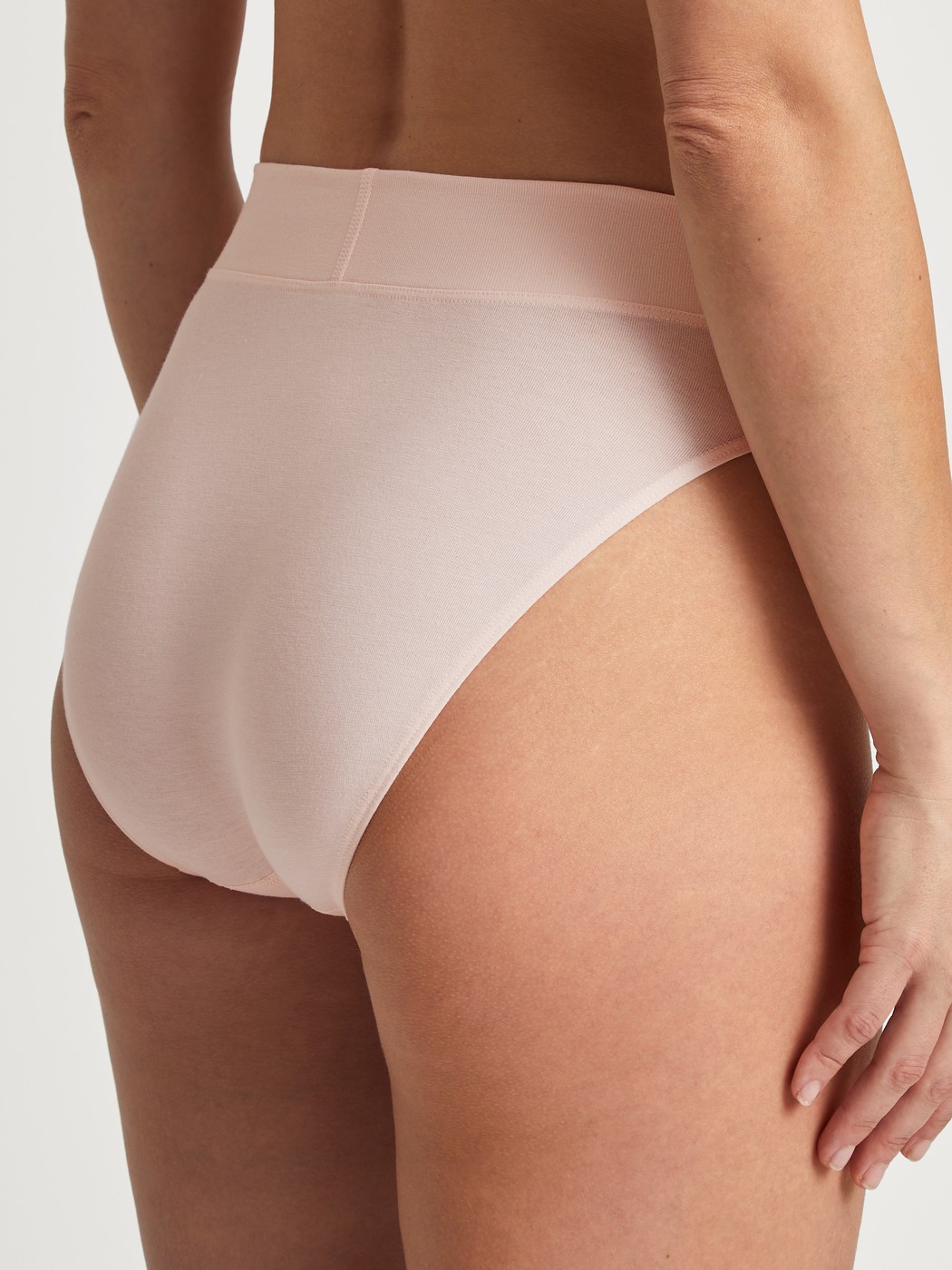 Women model is wearing High Waist Briefs, 2-Pack made of Cotton in Pink, Unicoloured from the Elastic Duopack series by CALIDA, Back view