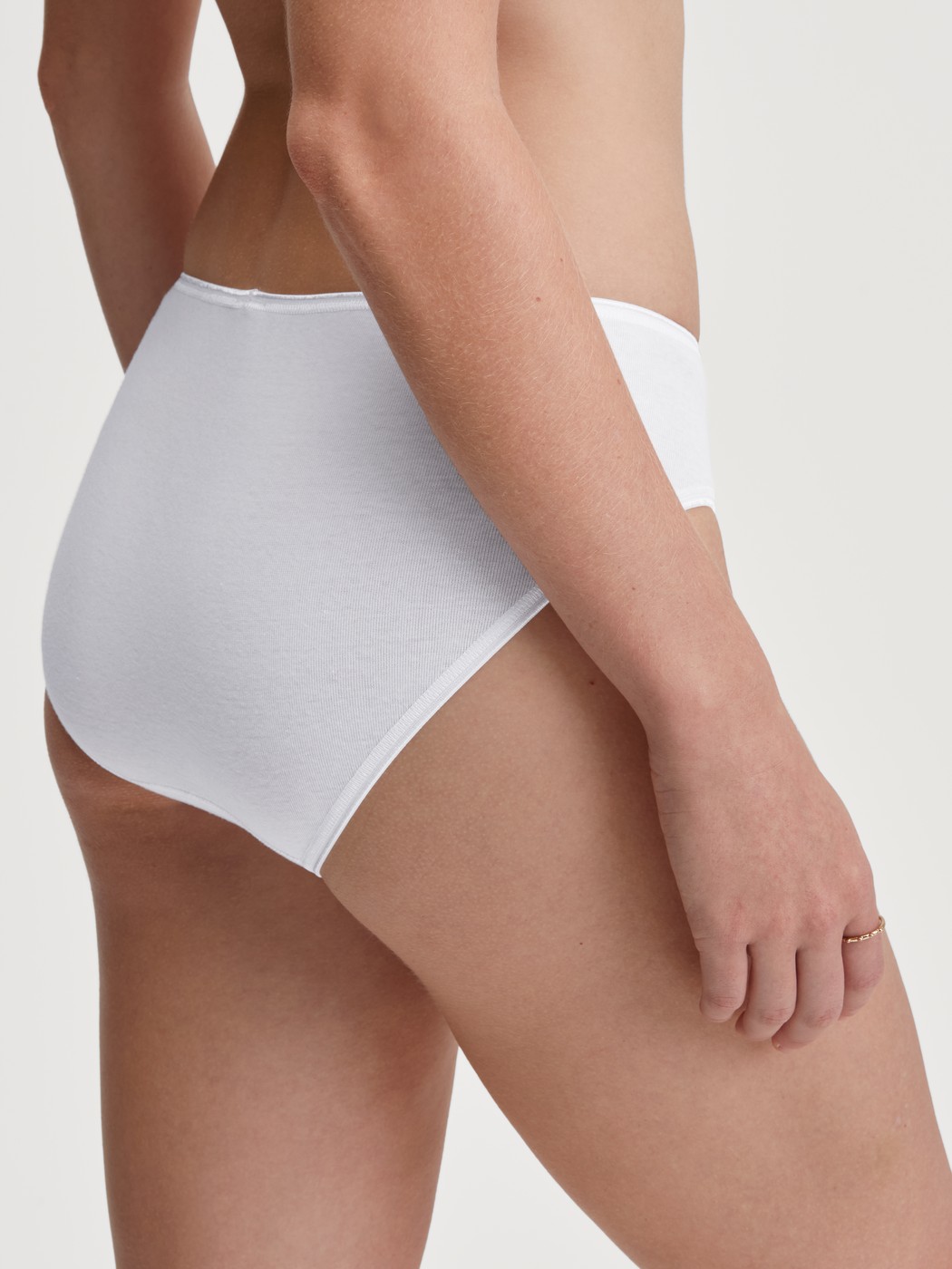 Damen-Model trägt Mini-Slip aus 100% Baumwolle in Weiß, Spitze aus Serie Cotton Desire von CALIDA, Rückansicht