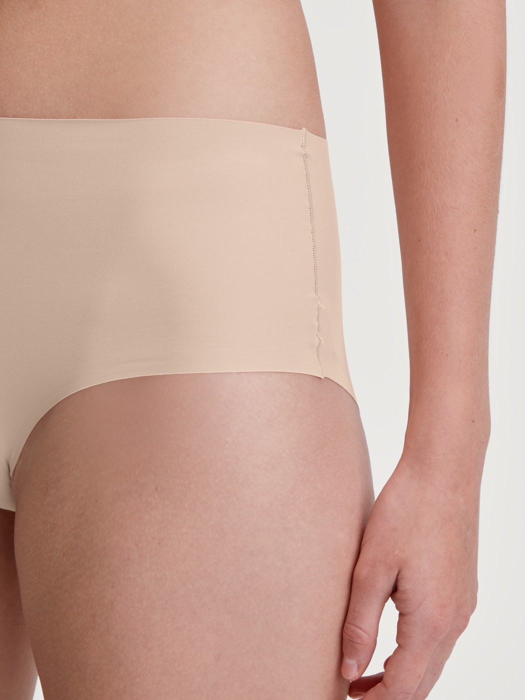 Damen-Model trägt Nahtloser Midi-Slip, Clean-Cut aus Polyamid in Rosa, Einfarbig aus Serie Sleek Skin von CALIDA, Detail