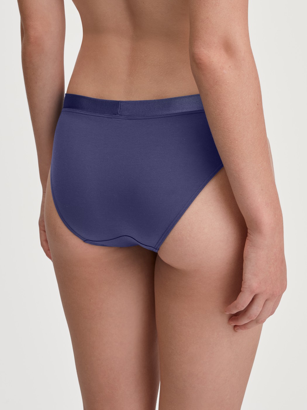 Damen-Model trägt Slip aus Baumwolle in Blau, Einfarbig aus Serie Cate von CALIDA, Rückansicht