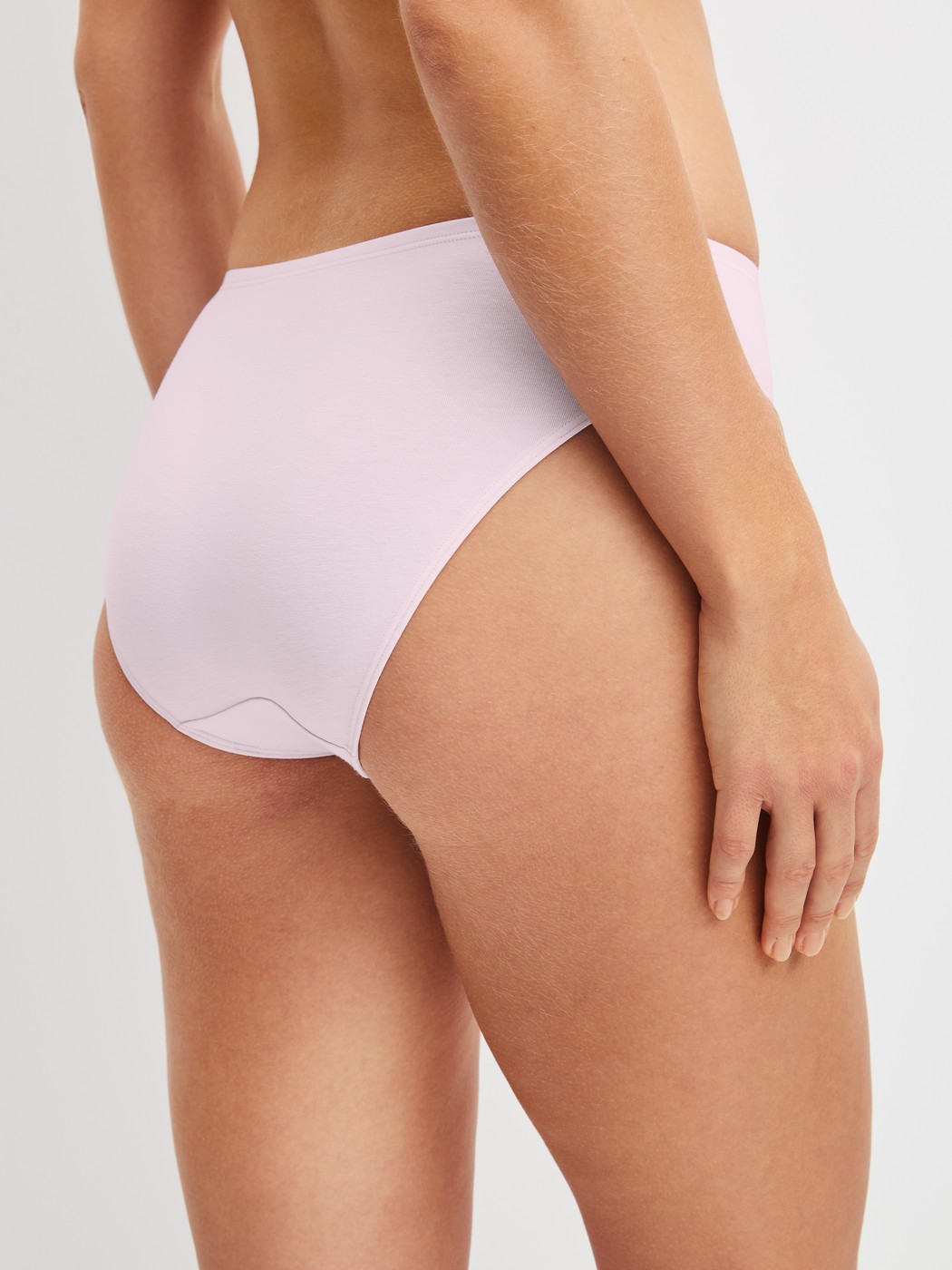 Damen-Model trägt Slip, regular cut aus Baumwolle in Rosa, Einfarbig aus Serie Essential Cotton von CALIDA, Rückansicht