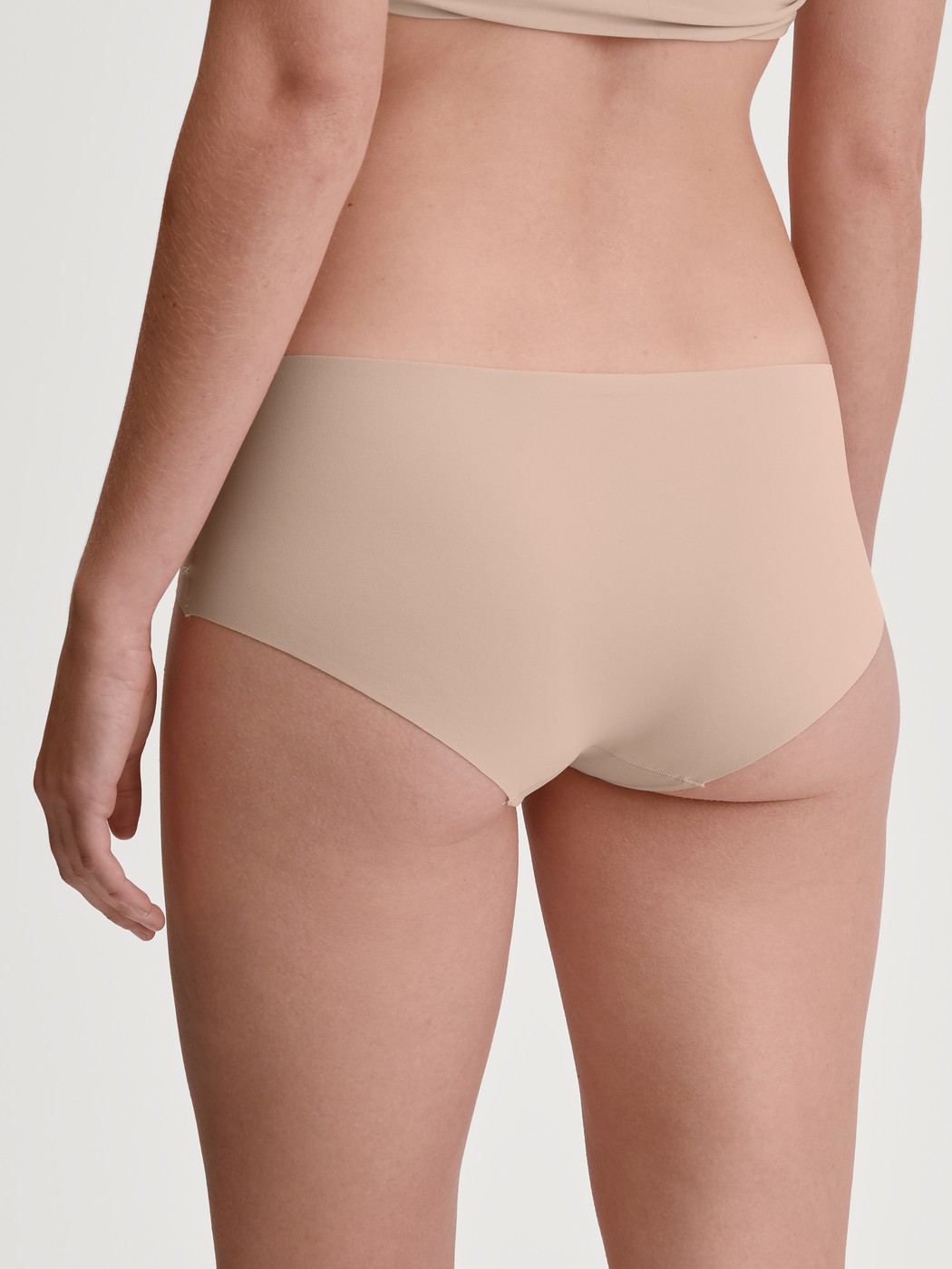 Damen-Model trägt Nahtlose Hipster-Panty Clean-Cut aus Polyamid in Rosa, Einfarbig aus Serie Sleek Skin von CALIDA, Rückansicht
