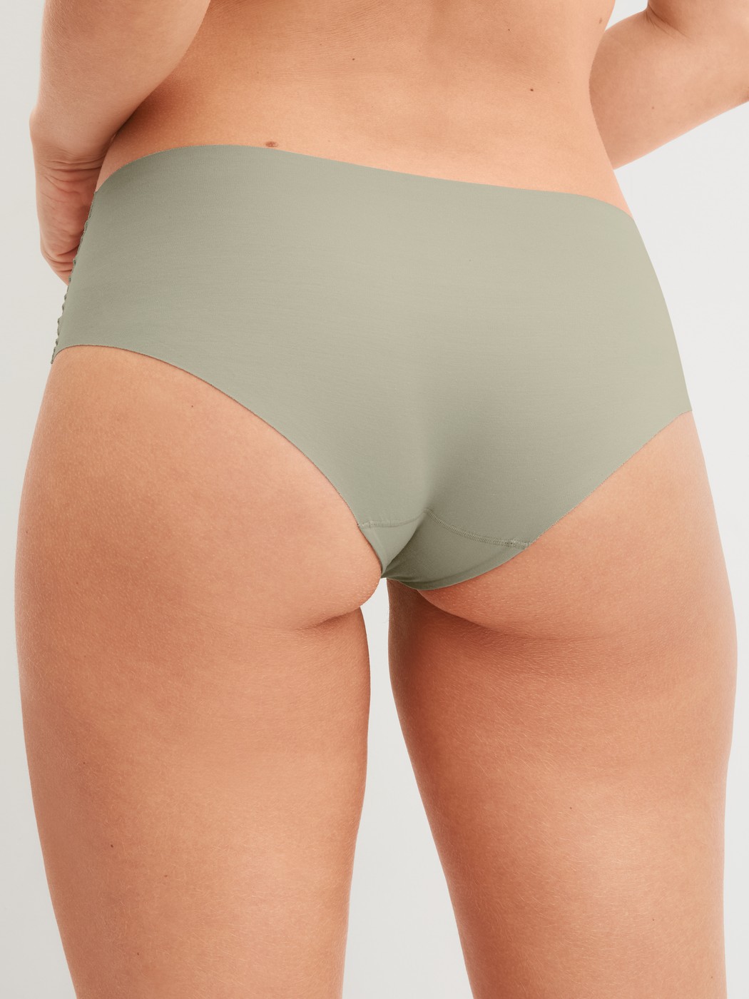 Damen-Model trägt Seamless-Panty, low cut aus Modal in Grün, Einfarbig aus Serie Natural Skin von CALIDA, Rückansicht