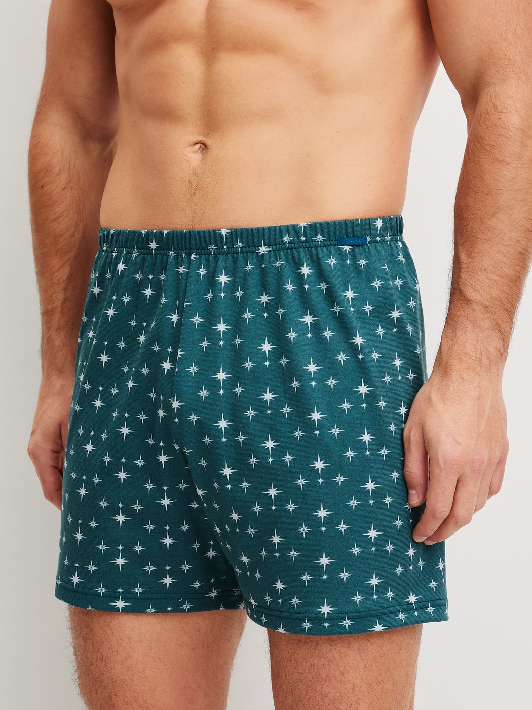 Herren-Model trägt Jersey-Boxershorts ohne Eingriff aus 100% Baumwolle in Türkis, Gemustert aus Serie Prints von CALIDA, Vorderansicht