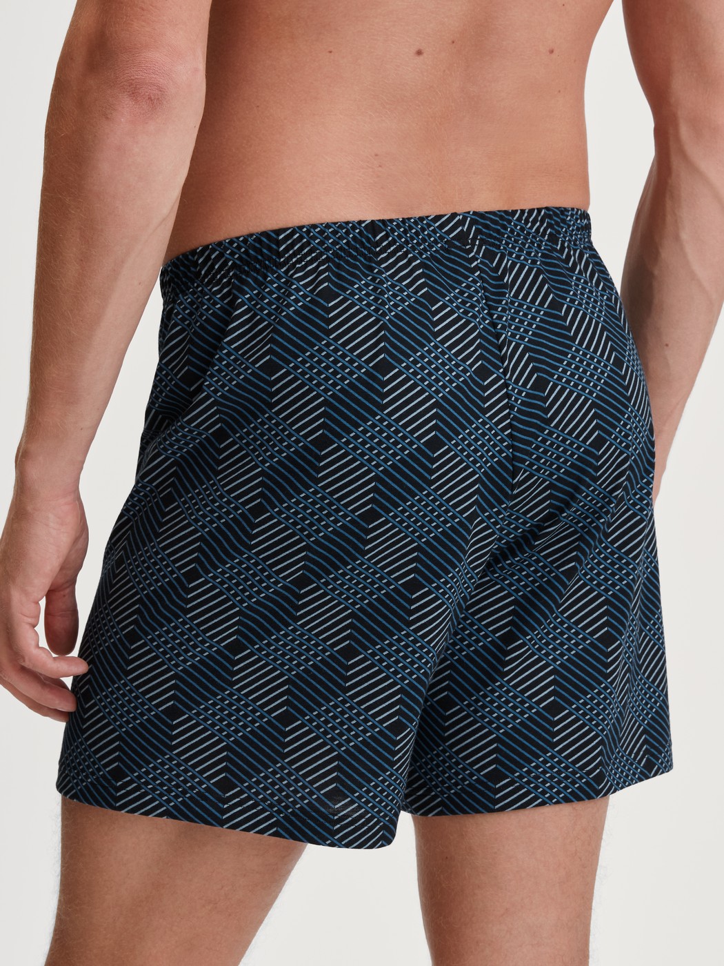 Herren-Model trägt Jersey-Boxershorts ohne Eingriff aus 100% Baumwolle in Schwarz, Gemustert aus Serie Prints von CALIDA, Rückansicht