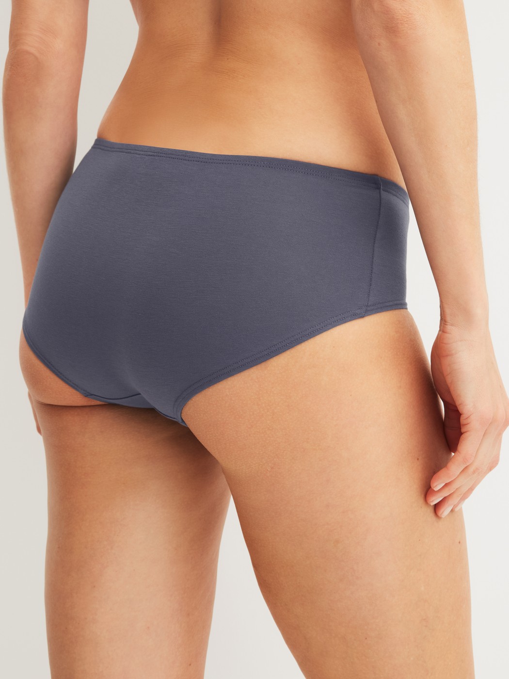Damen-Model trägt Panty, low cut aus Baumwolle in Grau, Einfarbig aus Serie Essential Cotton von CALIDA, Rückansicht